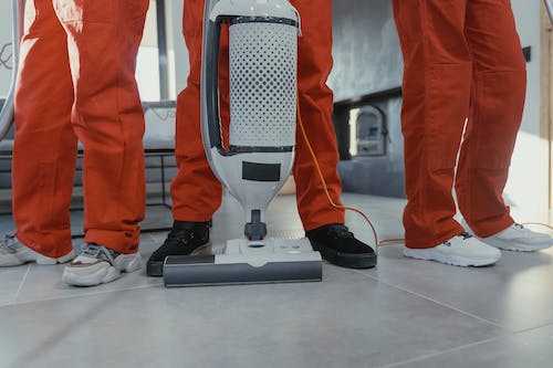 feet of three cleaning professionals and a vacuum cleaner